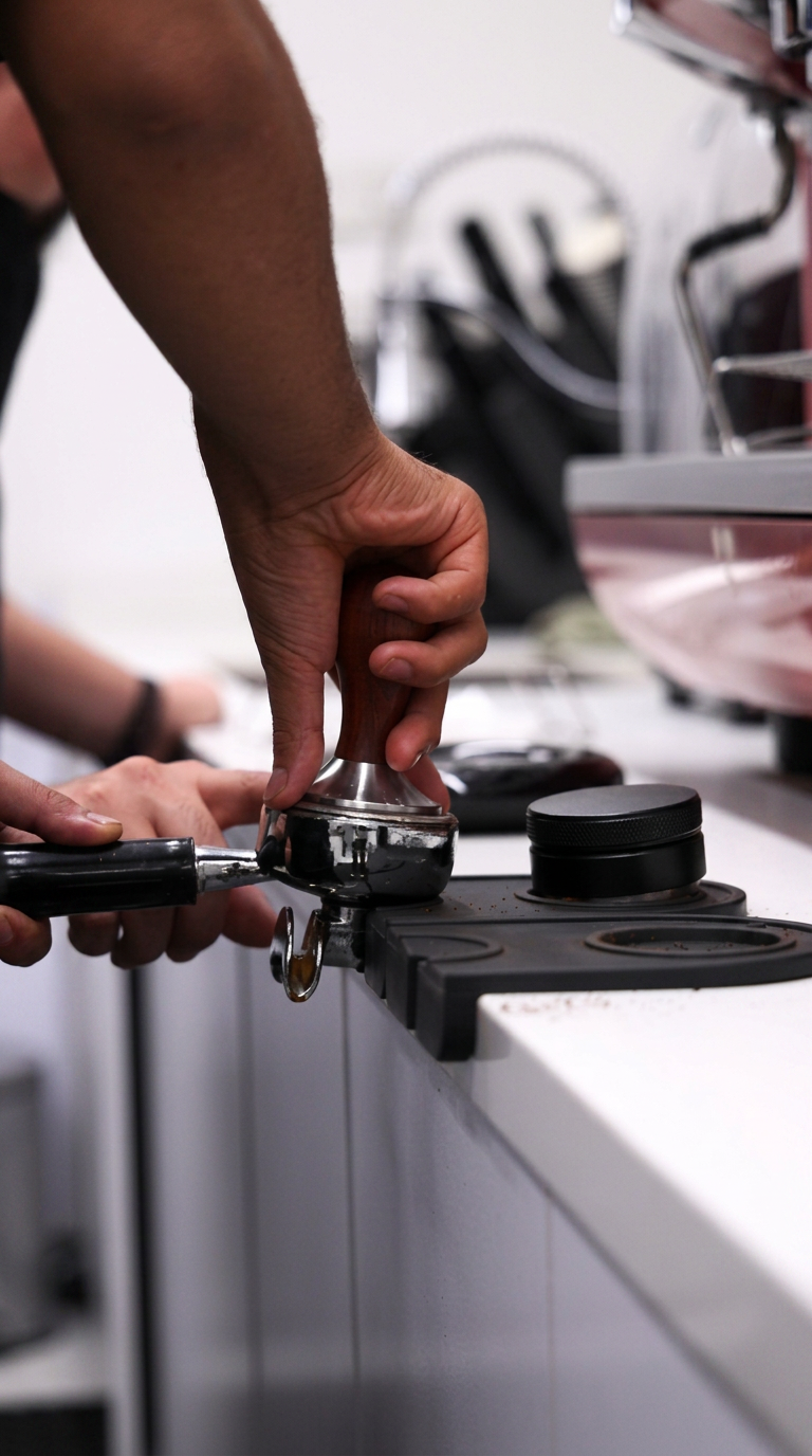 Trainee barista pulling an espresso shot on a professional machine